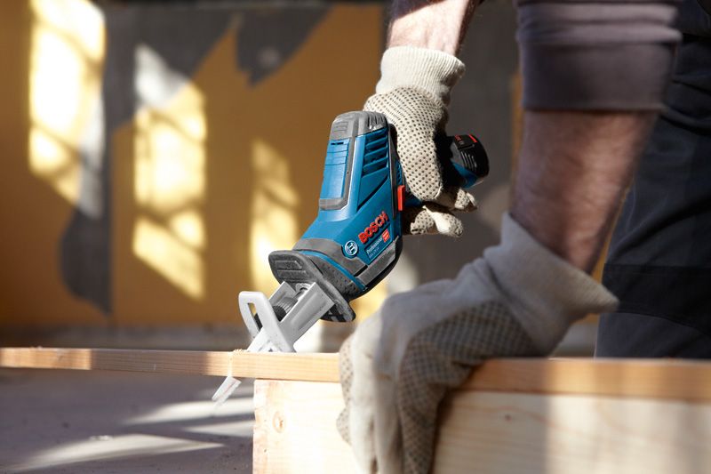 GSA 12V-Li A person wearing safety equipment uses a cordless reciprocating saw to cut wood.