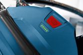 Battery indicator on a blue cordless dust extractor shows full charge.