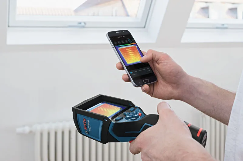 GTC 400 C A person uses a thermo camera and smartphone to view a thermal image indoors.