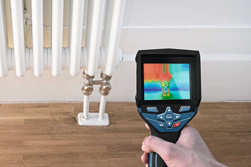 GTC 400 C A person uses a thermo camera to inspect heat distribution on a radiator.