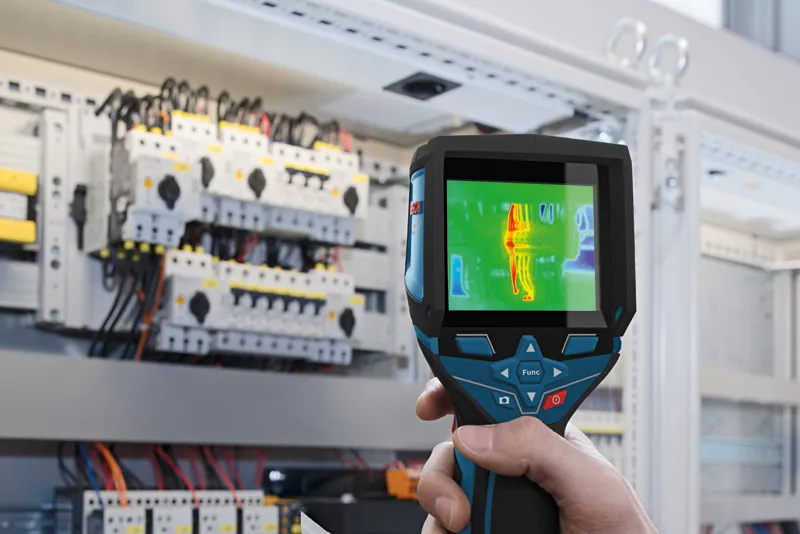 GTC 400 C Person uses a thermo camera to inspect electrical panels for heat anomalies.