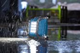 Work light operating on a wet floor during heavy rain at a construction site.