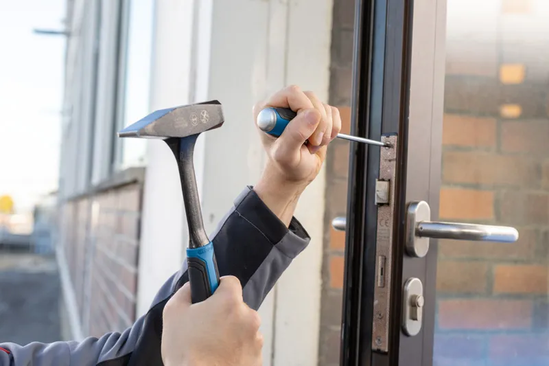 Screwdriver Set 6pc SL/PH/PZ/TX Person using a hammer and screwdriver to install a door lock mechanism.