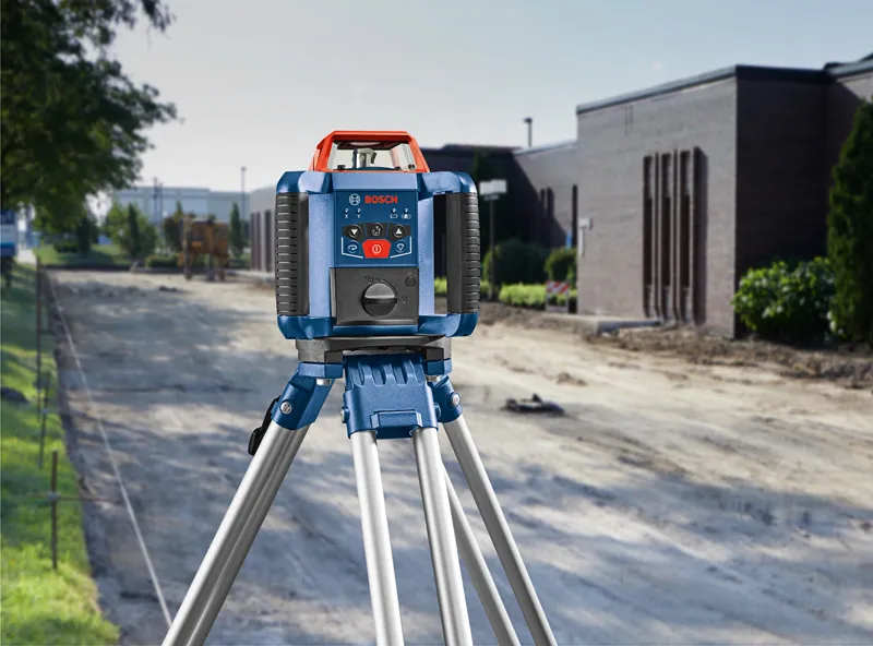 GRL 350 HV Laser leveling tool set on a tripod at a construction site beside a building.
