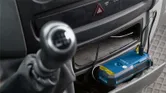 Battery pack charging in a car console via USB cable.