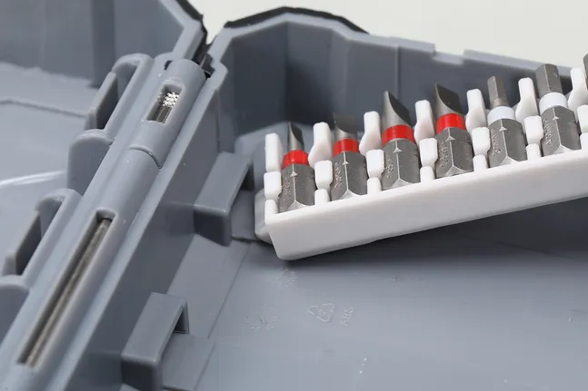 Assorted screwdriver bits organized in a plastic holder inside a gray tool case.