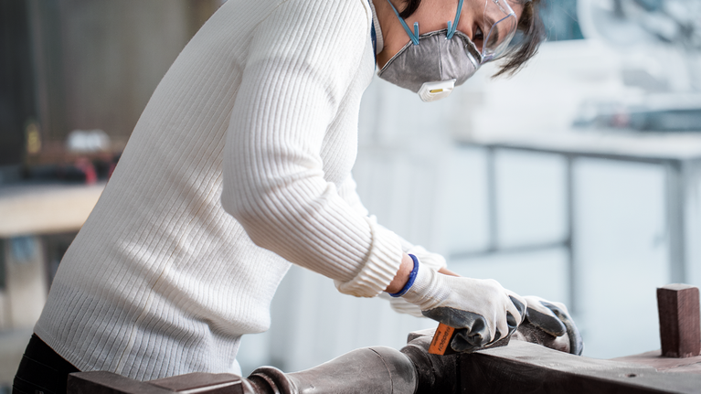 EXPERT S471 Standard Sanding Block, 26 x 69 x 97 mm, Medium, Fine, Super Fine, 3 pcs Person wearing safety equipment sands a metal surface in a workshop.