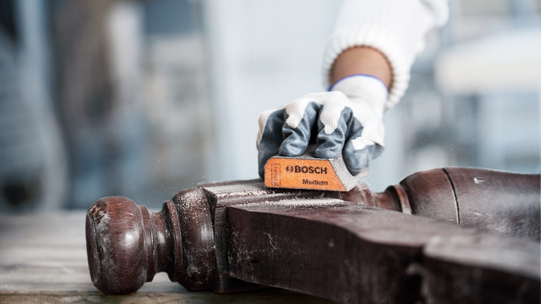 EXPERT S471 Standard Sanding Block, 26 x 69 x 97 mm, Medium, Fine, Super Fine, 3 pcs Person wearing safety equipment sands a wooden chair armrest.