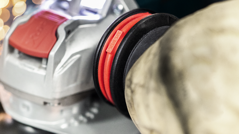 EXPERT Handle for Vibration Control M10 Angle Grinder 169 x 69 mm Power tool attached to a large flexible hose connection for dust extraction.