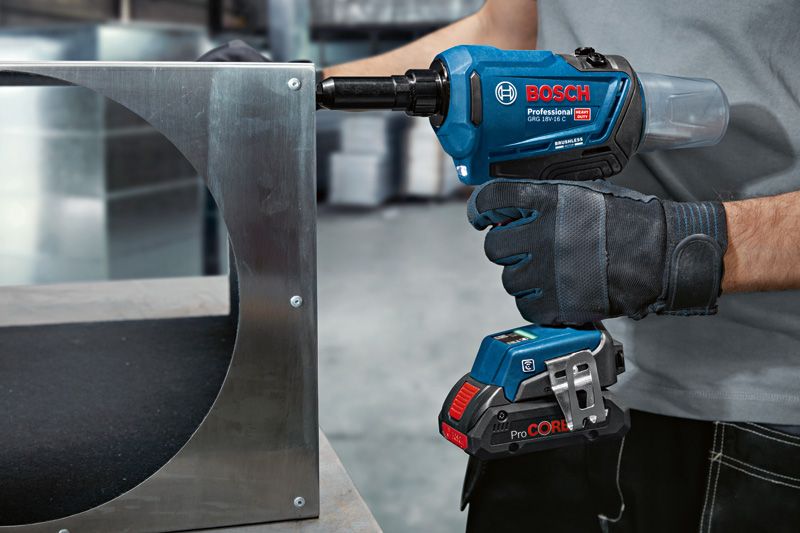 GRG 18V-16 C A person wearing safety equipment uses a cordless rivet gun on a metal frame.