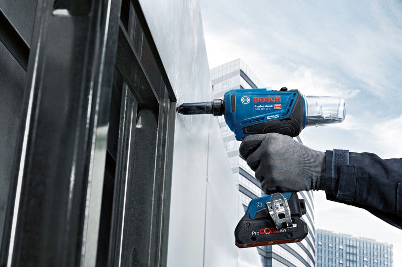 GRG 18V-16 C A person wearing safety equipment fastens a metal panel with a cordless rivet gun.
