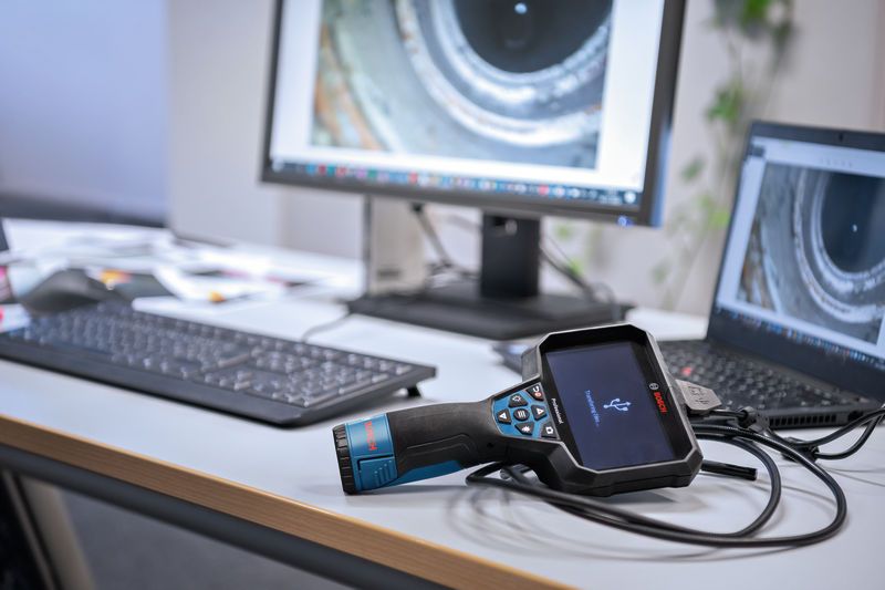 GIC 5-27 C Inspection camera connected to a laptop on an office desk with pipe images on screens.