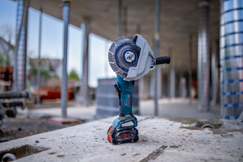GWS 18V-180 P Cordless angle grinder with a diamond blade standing upright on a concrete surface.