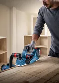 Bosch GHO 185-LI cordless planer smoothing wood surface.