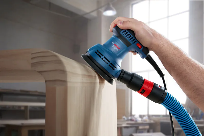 GEX 125 A person uses a random orbit sander on a rounded wooden surface.