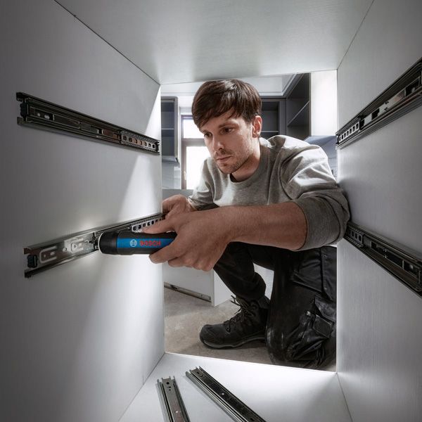 Bosch GO A person installs drawer slides in a cabinet using a cordless screwdriver.