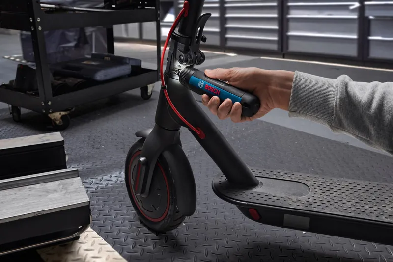 Bosch GO A person uses a cordless screwdriver to adjust the handlebar of an electric scooter.