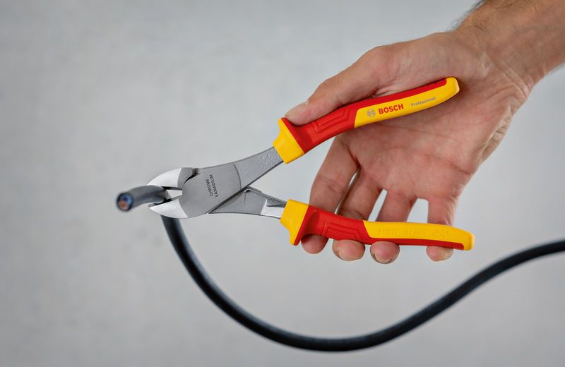 VDE High Leverage Dg. Side Cutter 200mm A person uses insulated diagonal side cutter pliers to cut a thick cable.