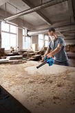 Bosch GBL 650 blower clearing sawdust from a workbench.