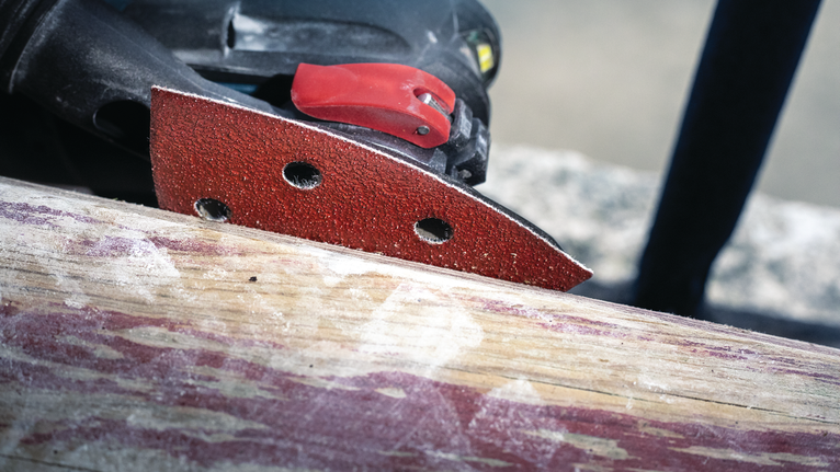 Detail sander smoothing a wooden surface.