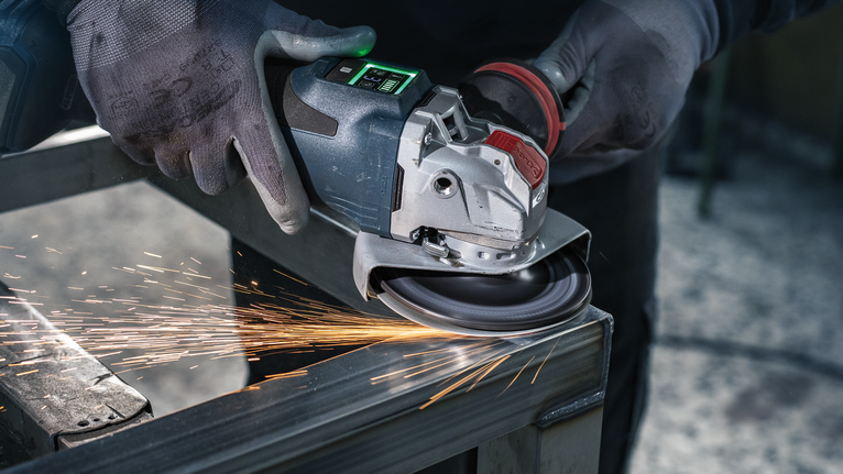PRO R780 X-Lock Fibre Disc, 125 mm, G36 A person wearing safety equipment grinds metal, producing sparks.