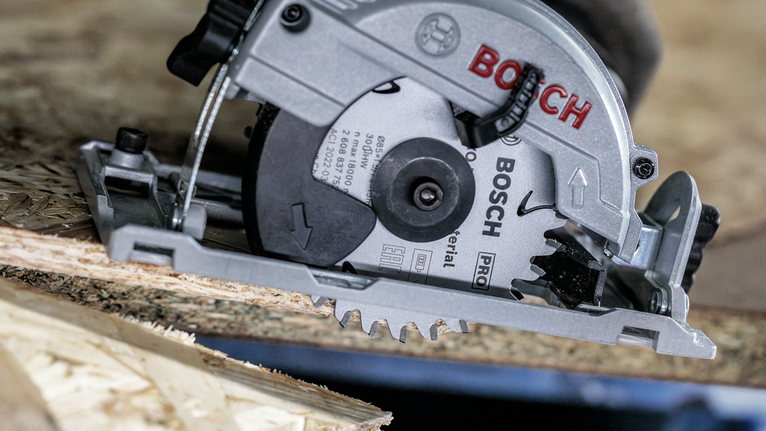 PRO Multi Material cordless Circular Saw Blade, 85 x 1.5 x 15 mm Circular saw cutting through a sheet of oriented strand board.