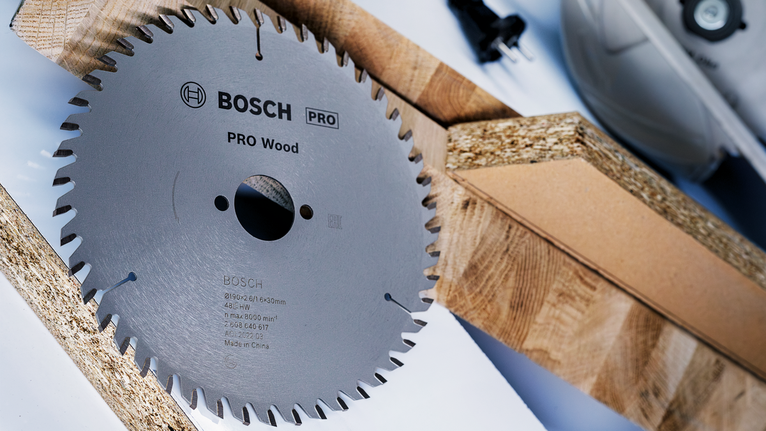 PRO Wood Circular Saw Blade, 184 x 2 x 20 mm Circular saw blade placed beside wooden planks on a work surface.