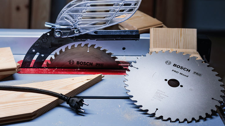 PRO Wood Circular Saw Blade, 406 x 3.2 x 30 mm Circular saw blades and wooden planks placed on a workbench in a workshop.