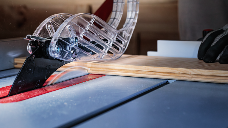PRO Wood Circular Saw Blade, 406 x 3.2 x 30 mm Person wearing safety equipment guides wood through a table saw blade in a workshop.