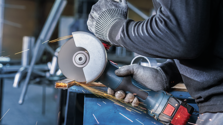 PRO Stainless Steel and Metal Bonded Cutting Disc, 115 x 1 x 22.23 mm, X-Lock, Straight Person wearing safety equipment grinds metal, producing sparks.