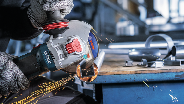 PRO Stainless Steel and Metal Bonded Cutting Disc, 115 x 1 x 22.23 mm, X-Lock, Straight A person wearing safety equipment grinds a metal pipe, producing sparks.