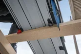 Track saw cutting through a wooden beam on a construction site.