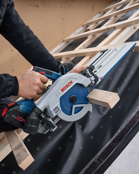 FSN 740 X Person operating a circular saw to cut wood on a sloped roof frame.