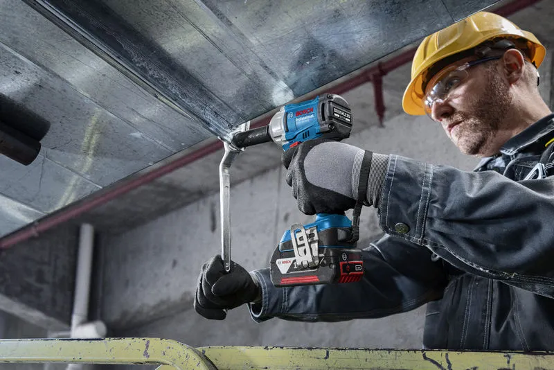 GDS 18V-350 A person wearing safety equipment uses a cordless impact wrench to fasten a metal beam.
