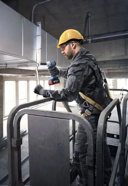 GDS 18V-350 A person wearing safety equipment uses a cordless power tool to fasten ductwork.
