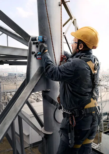 GDS 18V-350 A person wearing safety equipment uses a cordless drill on a metal structure.