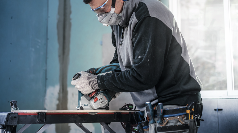 PRO Ceramic Diamond Disc, 105 x 20/16 mm Person wearing safety equipment uses a circular saw to cut wood on a workbench.