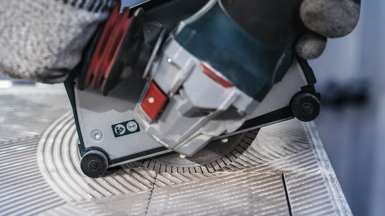 PRO Ceramic Diamond Disc, 105 x 20/16 mm Person wearing safety equipment uses a circular saw to cut a ceramic tile.