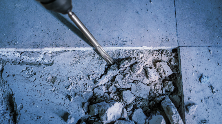 PRO SDS plus-5C Pointed Chisel, 250 mm Rotary hammer chisel breaking up a concrete floor.