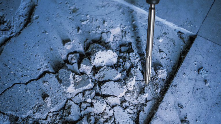 PRO SDS plus-5C Pointed Chisel, 250 mm Rotary hammer breaking apart a concrete floor.