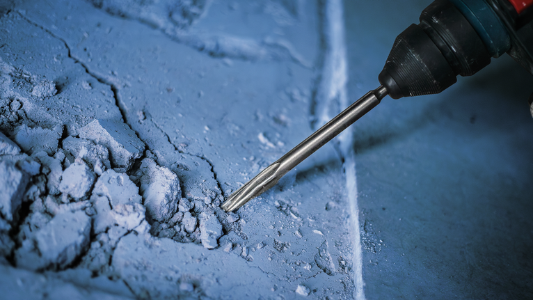 PRO SDS plus-5C Pointed Chisel, 250 mm Rotary hammer breaking concrete surface.