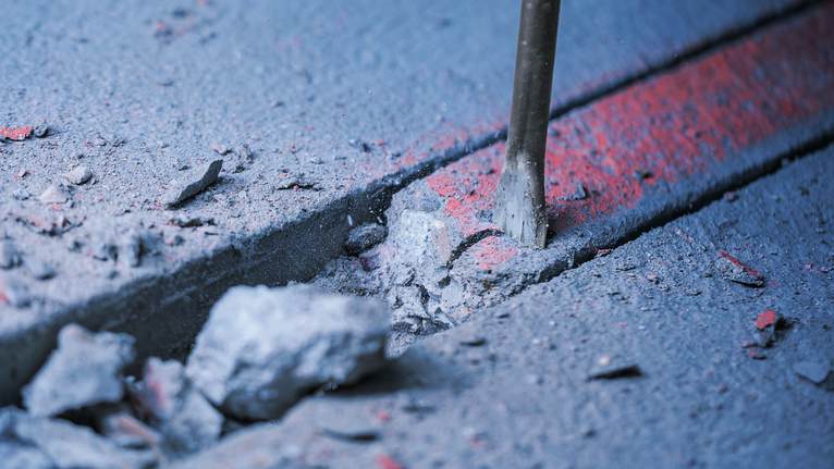 PRO SDS plus-5C Flat Chisel, 20 x 250 mm Chisel breaking concrete along a marked line.