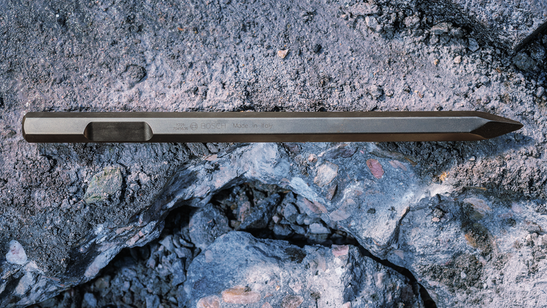 PRO HEX-4C Pointed Chisel 28 mm, 28 x 520 mm Pointed chisel resting on cracked concrete rubble.