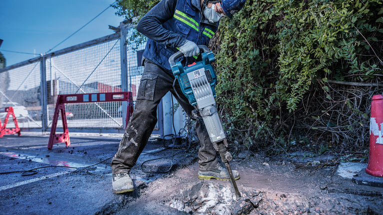 PRO HEX-4C Flat Chisel 30 mm, 35 x 400 mm A person wearing safety equipment breaks concrete with an electric demolition hammer.