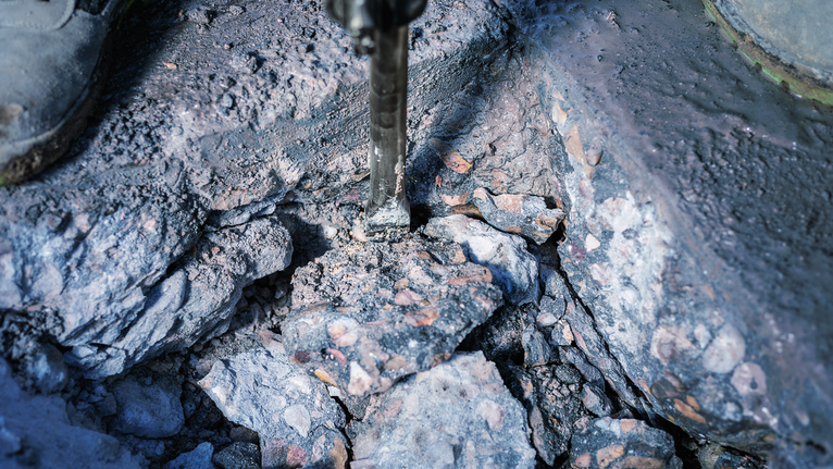 PRO HEX-4C Flat Chisel 30 mm, 35 x 400 mm Demolition hammer breaking concrete into large rubble pieces.