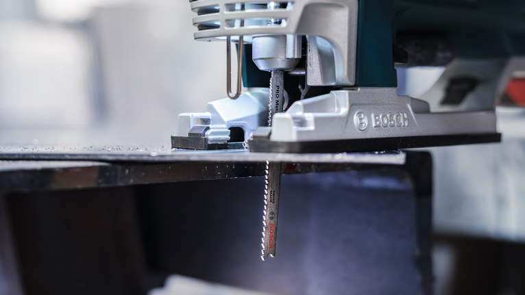 PRO Metal thick and thin T123XF Jigsaw Blade, 100 mm, 3 pcs Jigsaw cutting through a metal sheet in a workshop.