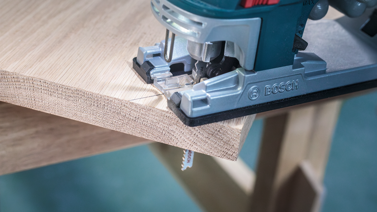Jigsaw cutting a precise curve into a wooden board.