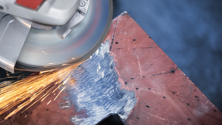 PRO Metal Grinding Disc, A 24 S BF, 180 x 6.6 x 22.23 mm, Depressed Centre Angle grinder producing sparks while sanding the edge of a metal sheet.