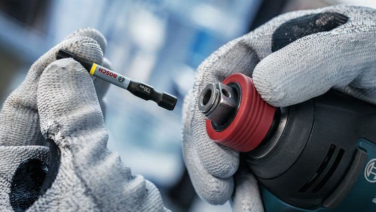 PRO PH Impact Bit, PH1 x 55, PH2 x 55, PH3 x 55 mm, 3 pcs Person wearing safety equipment inserts a screwdriver bit into a power drill.