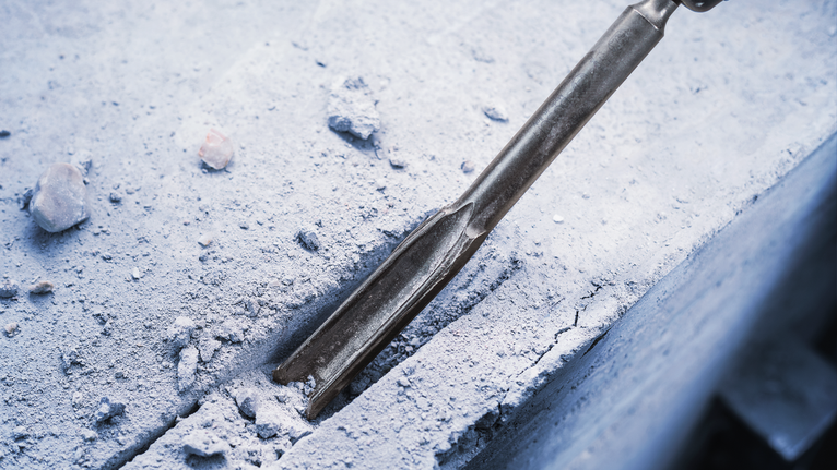 PRO SDS plus Hollow Gouging Chisel, 22 x 250 mm Chisel attachment breaking a straight groove into a concrete surface.